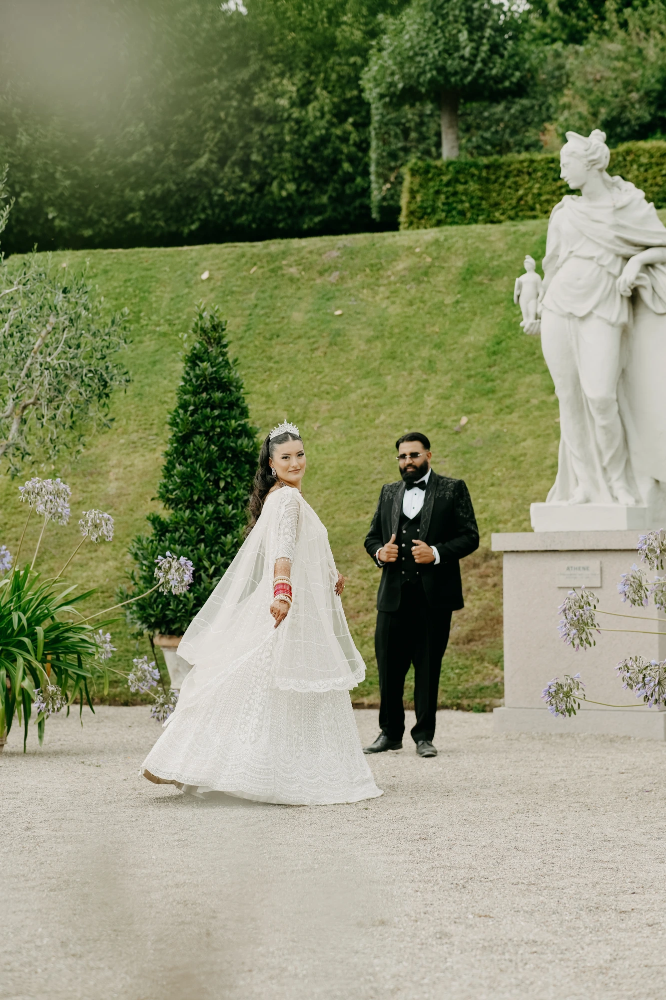 Bride in white gown turning in a palace garden
